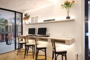 a kitchen with a bar with chairs and a desk with two monitors at Blue Hippo & Red Crocodile Hotel in Bangna +47 photos