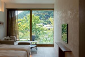 a hotel room with two beds and a large window at Muni Kyoto in Kyoto