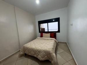 a small bedroom with a bed and a window at Residence Jade in Bir el Djir +2 photos