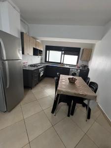 a kitchen with a table with chairs and a refrigerator at Residence Jade in Bir el Djir