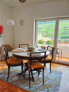 a dining room with a table and chairs and a window at Pinhão House in Pinhão