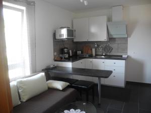 ein Wohnzimmer mit einem Sofa und einer kleinen Küche in der Unterkunft Ferienwohnung Wünsche in Weißensberg