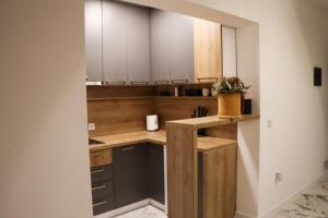a kitchen with white cabinets and a counter at Om relax apartman in Prijedor