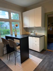 a kitchen with a black counter and white cabinets at Central Studio apartment in Notodden
