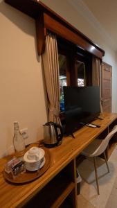 a wooden desk with a computer monitor on top of it at Mango Garden in Gili Islands