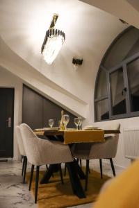 a dining room with a table and chairs and a chandelier at Om relax apartman in Prijedor +5 photos