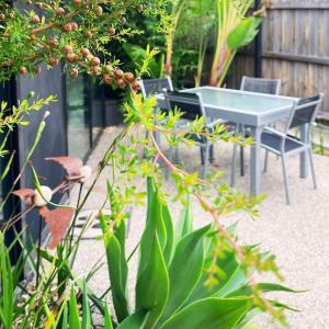 a table and chairs in a garden with plants at Fusion Townhouse-North Hobart in West Hobart +30 photos