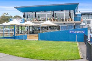 a building with tables and umbrellas in front of it at Montage Apartment + Views + Location + Car Parking in Bellerive