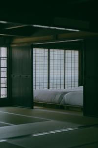 a bedroom with a bed in a room with windows at 暇家 kaya in Yosano