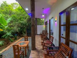 a porch with wooden chairs and tables and windows at Lake View Eco Lodge in Dambulla +27 photos