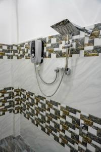 a shower in a room with a tile wall at Lake View Eco Lodge in Dambulla