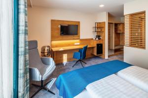 a bedroom with a bed and a desk and a television at Hotel Schwan & Post in Bad Neustadt an der Saale