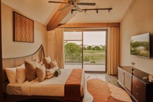 a bedroom with a bed and a sliding glass door at Arth Resorts I Convention I Wellness in Moinabad