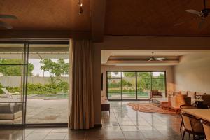 an open living room with glass doors to a patio at Arth Resorts I Convention I Wellness in Moinabad