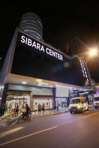 a s barra center à noite com carros estacionados na frente em Hotel Sibara SPA & Convenções em Balneário Camboriú