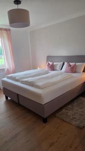 a large bed with pink pillows in a bedroom at Bachwagnerhof in Staudach-Egerndach