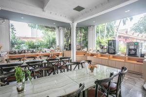 ein großes Esszimmer mit Tisch und Stühlen in der Unterkunft Windmill Resort Hotel Pattaya in Pattaya North