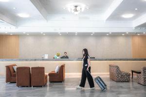 Eine Frau, die mit einem Koffer durch eine Lobby geht in der Unterkunft Windmill Resort Hotel Pattaya in Pattaya North + 181 Fotos