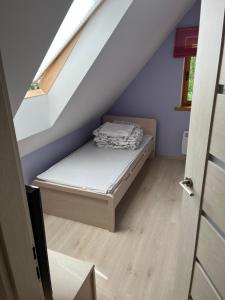 a small bedroom with a bed in the attic at Przystanek Jezioro - Kaszuby in Studzienice