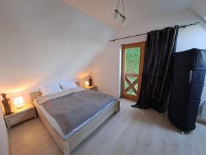 a bedroom with a large bed and a window at Przystanek Jezioro - Kaszuby in Studzienice