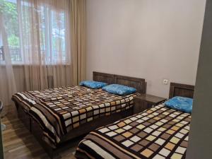 two beds sitting in a room with a window at Guest House Guro kobuleti in Kobuleti +4 photos