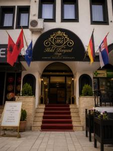a building with flags in front of a building at Hotel Beograd Struga in Struga