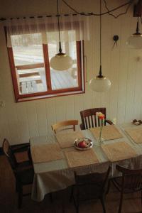 a dining room with a table with chairs and lights at Jarzębinowa - artystyczny dom na Podlasiu in Łuka +64 photos