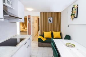 a kitchen and a living room with a table and a couch at Villa Bazilika in Sečovlje