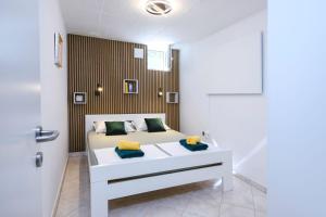 a bedroom with a white bed and a wooden wall at Villa Bazilika in Sečovlje +45 photos