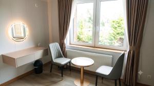 ein Zimmer mit einem Tisch, zwei Stühlen und einem Fenster in der Unterkunft Zen Garten in Ahrensfelde