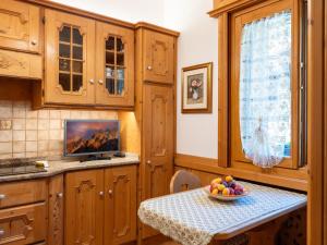 a kitchen with a table with a bowl of fruit on it at Villa Marmarole - Croda Bianca Apartment in Calalzo