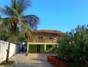 a house with a palm tree in front of it at Araçagy Casa Mar in São José de Ribamar