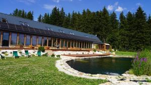 a house with a pond in front of it at Rancho Lawendowe in Szczytna