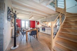 a kitchen and dining room with a staircase in a loft at Les Grandes Vagastines in Saint-Germain-du-Plain