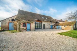 an old stone house with blue doors on a gravel driveway at Les Grandes Vagastines in Saint-Germain-du-Plain