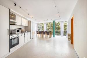 a kitchen with white cabinets and a table and chairs at Apartments Lübeck in Lübeck