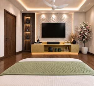 a bedroom with a flat screen tv and a bed at Hotel La Casa Near Delhi Airport in New Delhi