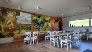 a dining room with a table and chairs and a mural at Rancho Lawendowe in Szczytna