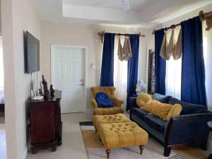 a living room with a couch and a chair at Oceanpointe Serenity Get Away-solar pool WiFi in Lucea
