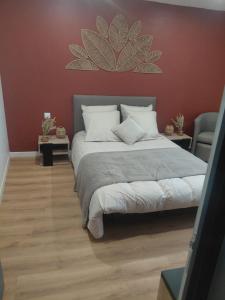 a bedroom with a large bed and a red wall at Chambre in Ploumilliau