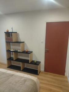 a bedroom with a book shelf next to a door at Chambre in Ploumilliau