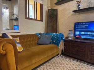 a living room with a couch and a flat screen tv at Casa Artista in Pedro Bernardo