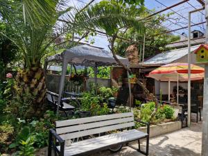 a wooden bench sitting in front of a garden at Guest House Guro kobuleti in Kobuleti
