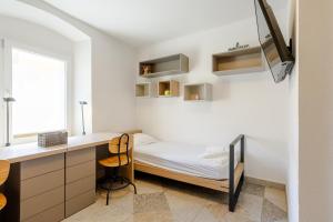 a small bedroom with a bed and a desk at Casa Riccobon in Koper