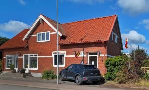 a car parked in front of a brick house at Glemminge Bed & Bastu in Glemminge