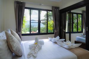a bedroom with a large white bed with flowers on it at Baan Chom View Kamala - SHA Plus in Kamala Beach +124 photos