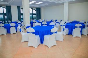 a banquet hall with blue and white tables and chairs at The Dalton Grand Hotel in Murangʼa