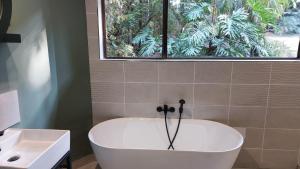 a bath tub in a bathroom with a window at Guesthouse Charis in Pretoria +37 photos