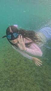 a young girl is swimming in the water at Hostal Fragata Puerto López in Puerto López +26 photos