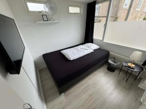 a small bed in a small room with a window at Slottets Anneks in Rønne +7 photos